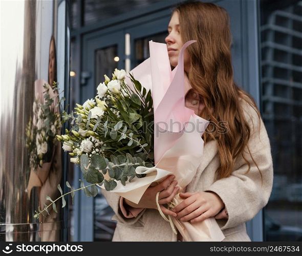 front view stylish woman outdoors holding bouquet flowers
