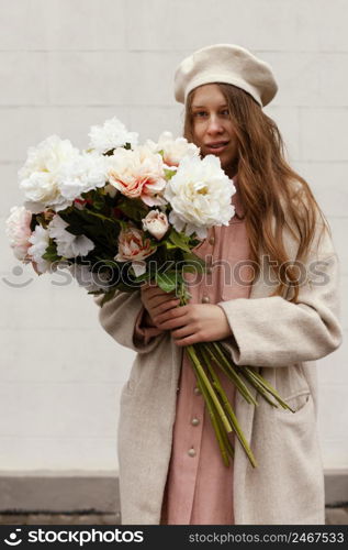 front view stylish woman outdoors holding bouquet flowers spring