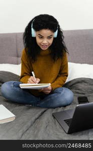 front view teenage girl using laptop online school