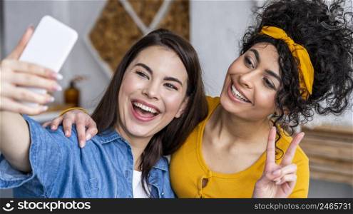 front view two happy women laughing taking selfie
