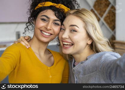 front view two happy women taking selfie