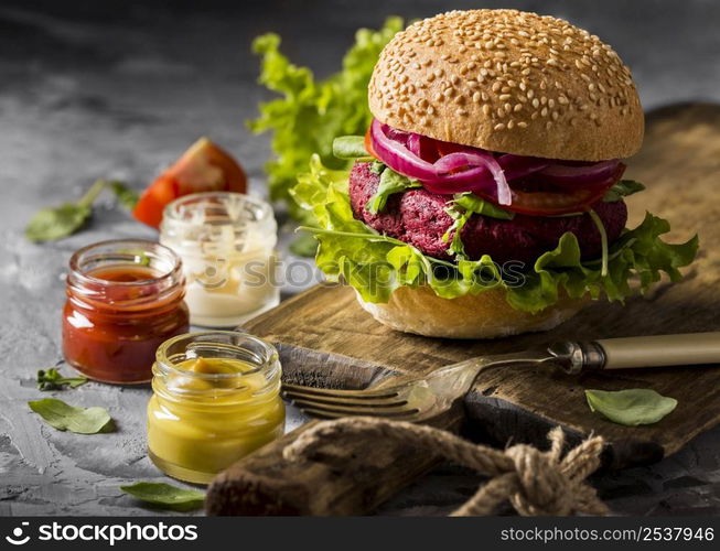 front view vegetarian burger cutting board with sauces