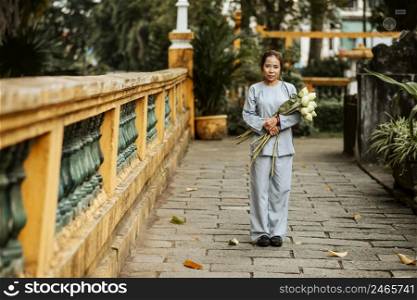 front view woman holding bouquet flowers temple
