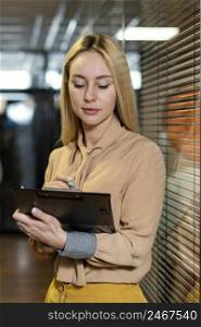 front view woman holding clipboard workplace