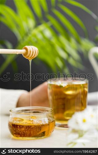 front view woman holding glass with tea honey dipper. High resolution photo. front view woman holding glass with tea honey dipper. High quality photo