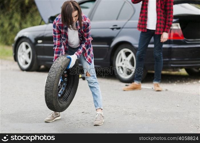 front view woman holding tire