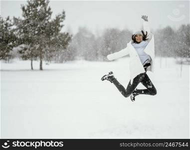front view woman jumping air outdoors winter