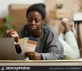 front view woman making plans redecorate house with laptop color palette