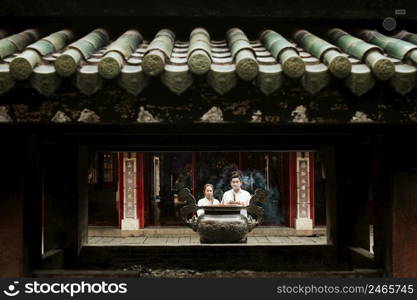 front view woman man praying temple with burning incense 2