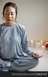 front view woman meditating candles with copy space