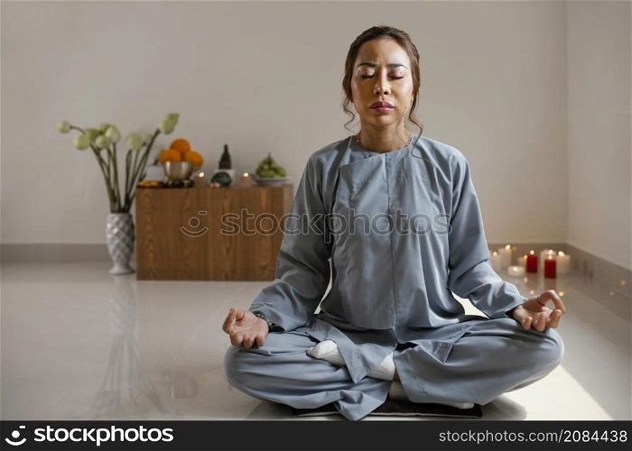 front view woman meditating room with copy space