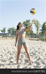 front view woman posing with volleyball beach