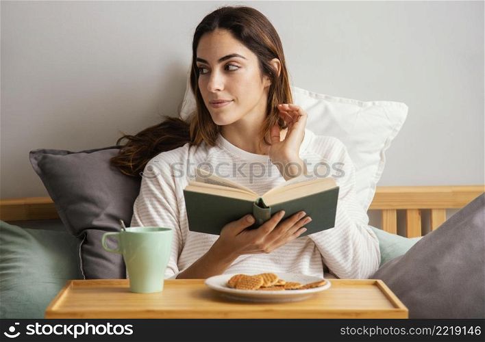 front view woman reading having breakfast home