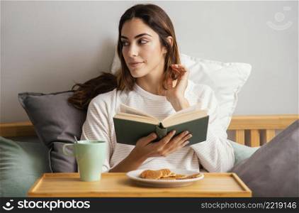 front view woman reading having breakfast home