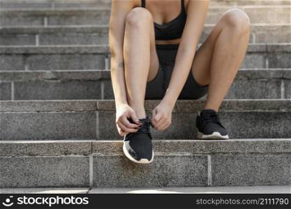 front view woman tying her shoelaces before exercising