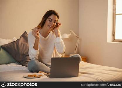 front view woman using laptop home talking phone