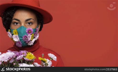 front view woman with mask holding flowers bouquet