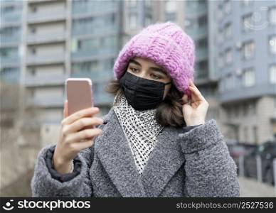 front view woman with medical mask city taking selfie