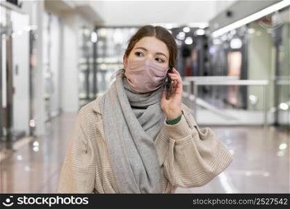 front view woman with medical mask talking phone
