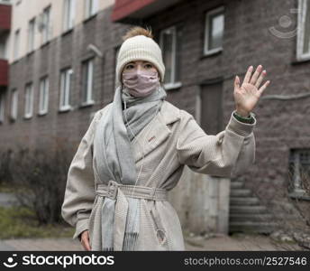 front view woman with medical mask waving