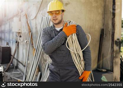 front view worker with hard hat carrying rope
