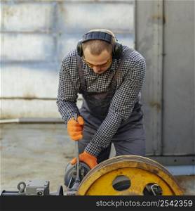front view worker with protective gloves headphones