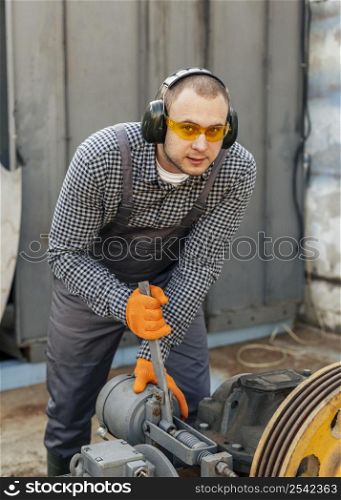 front view worker with safety glasses headphones