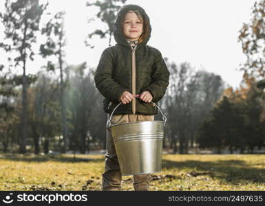 front view young boy outdoors holding bucket