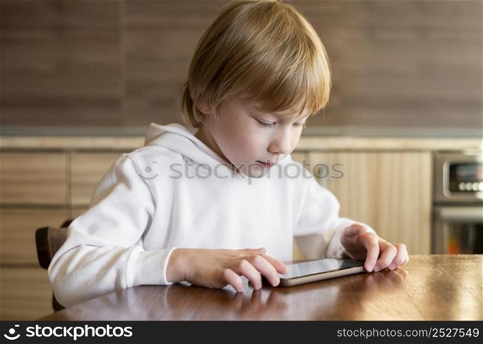 front view young boy using smartphone table