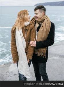 front view young couple winter by beach