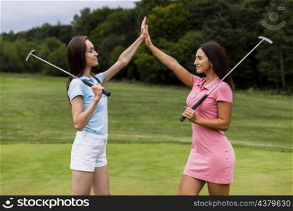 front view young golfers high fiving