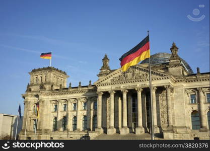 Frontal view of Reichstag building with German flag waving in a beautiful day with blue sky, Berlin, Germany, Europe.