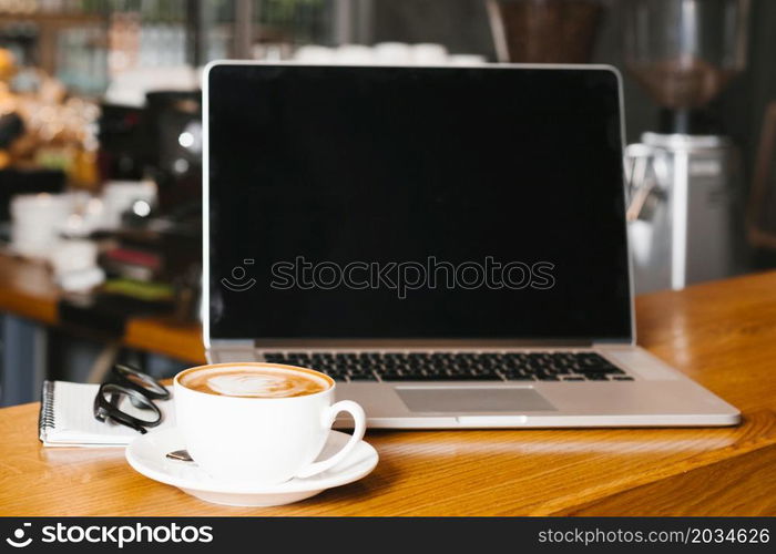 frontview laptop coffee wooden surface