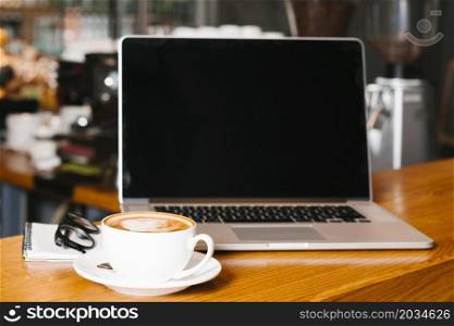 frontview laptop coffee wooden surface