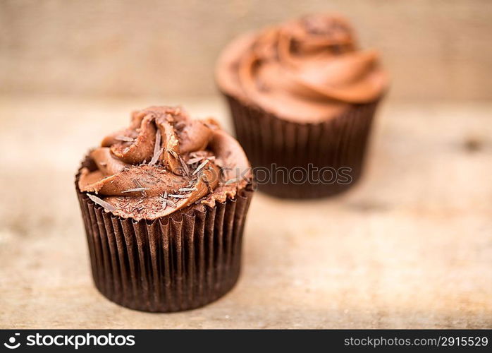 Frosted cupcakes on rustic background