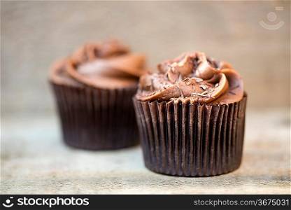 Frosted cupcakes on rustic background