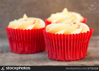 Frosted cupcakes on rustic background
