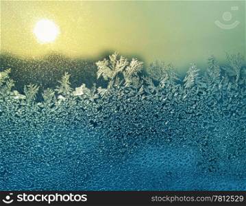 frosty natural pattern and sun on glass of winter window