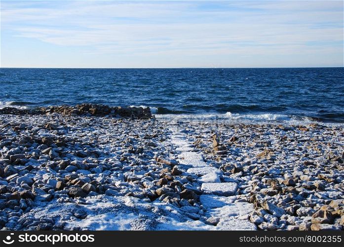 Frosty path to the beach at the flat rock coast of the swedish island Oland in the Baltic Sea.