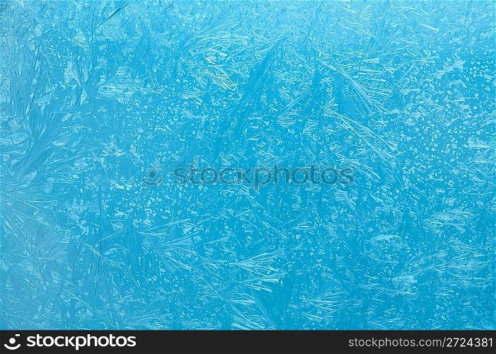 Frosty pattern on glass on a blue background