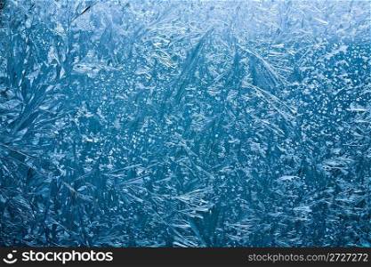 Frosty pattern on glass on a blue background