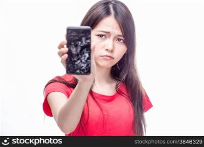 Frowning Chinese woman holding cell phone with cracked screen