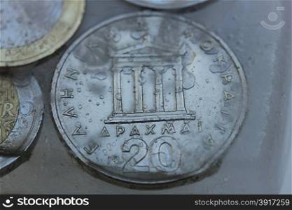 Frozen Assets: Greek euro and Drachme coins in ice