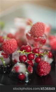 Frozen berries on wooden table. Fresh frozen berries raspberry and red currant