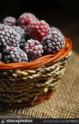 frozen blackberries in basket on old wood