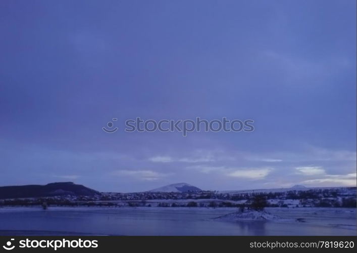 Frozen lake and stormy weather in wintertime