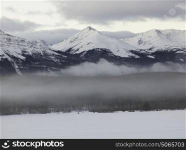 Frozen lake with snowcapped mountain range in the background, Pyramid Lake, Highway 16, Jasper, Jasper National Park, Alberta, Canada