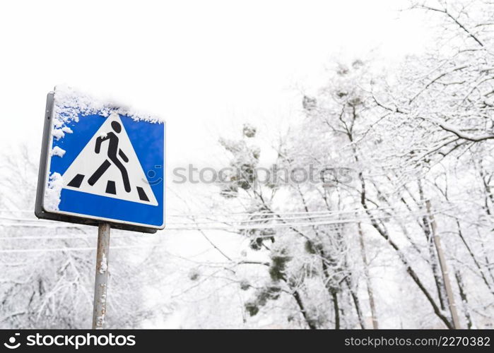 Frozen pedestrian sign covered in snow on a frosty snowy day. Frozen pedestrian sign covered in snow on a frosty snowy day.