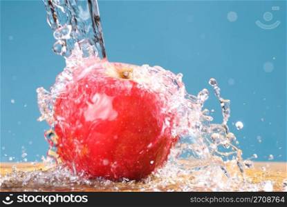 frozen splash drop on apple, cool water on blue background
