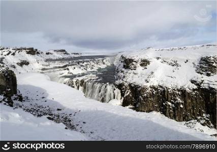 frozen waterfall and mountains in the winter on island iceland